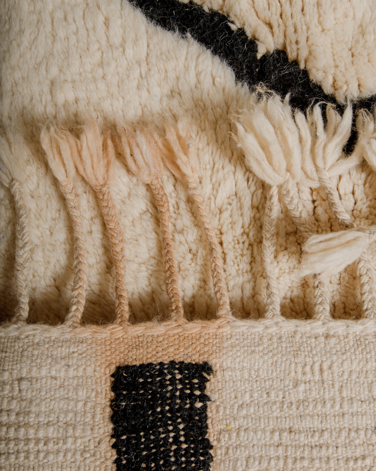 Back of wool rug showing discolouration from black dye.
